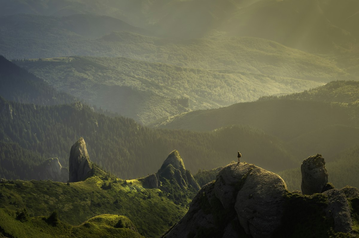 Sunlight breaking through clouds over hills